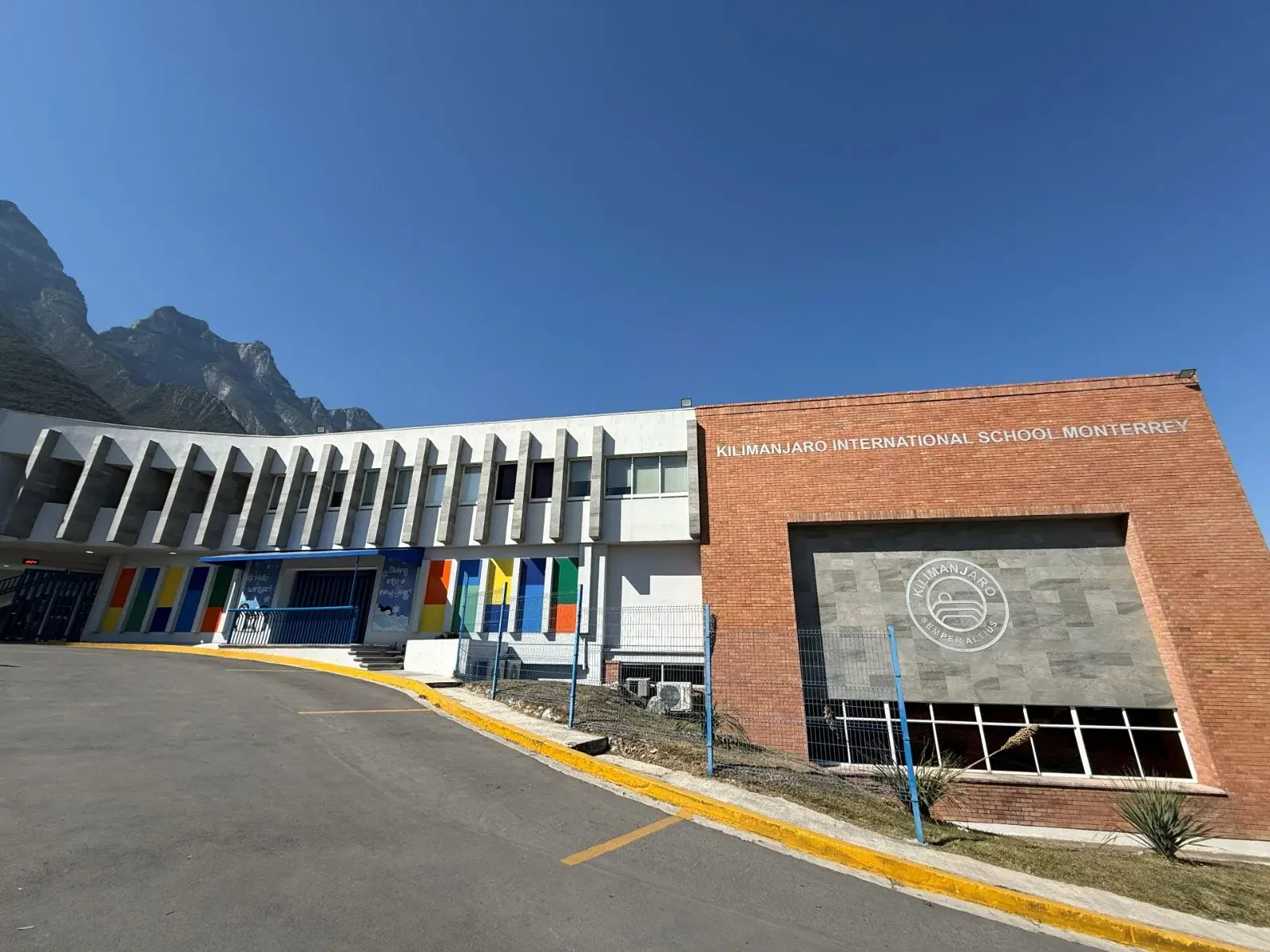 Fachada moderna del Kilimanjaro International School Monterrey con arquitectura contemporánea y montañas de fondo